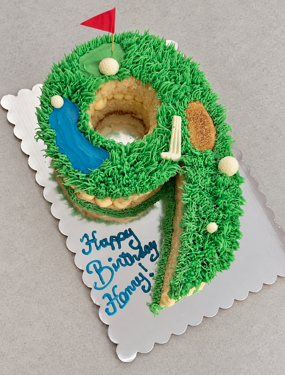 Number nine cake decorated as a golf course with a red flag